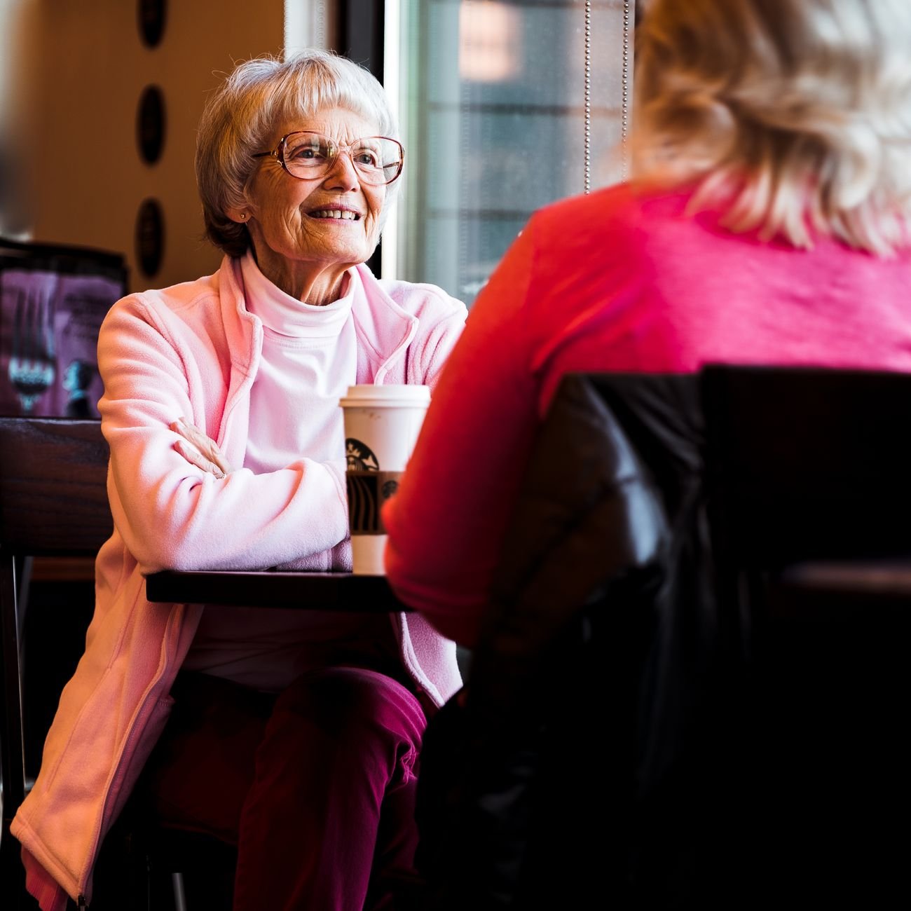 Smiling older woman sitting at a café table