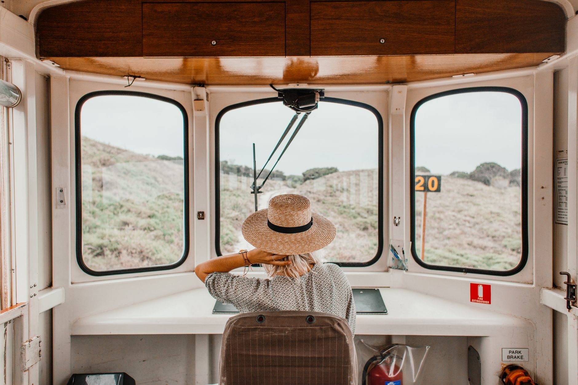 Back view of a woman with straw hat on a scenic train ride